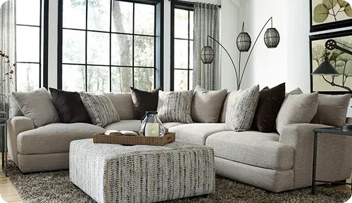 A cozy living room with a modern light-colored sectional sofa adorned