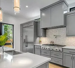 Modern kitchen featuring gray cabinets, a sleek gas stove