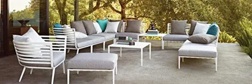 Modern outdoor seating area with white metal frames and gray cushions