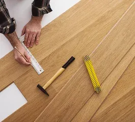 A person measuring wooden planks with a ruler